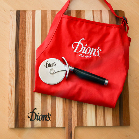 A handmade red apron, perfect for Dion's Fan Shop's Chef Bundle, with a knife and a cutting board.
