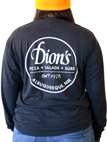 A woman wearing a black Est. 1978 - Long Sleeve Tee that says Dion's, pizza, salads, & subs, Albuquerque, NM. 