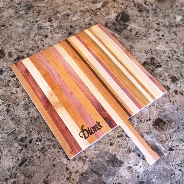 A Dion's Fan Shop Chef Bundle handmade wooden cutting board with the name of a person on it.