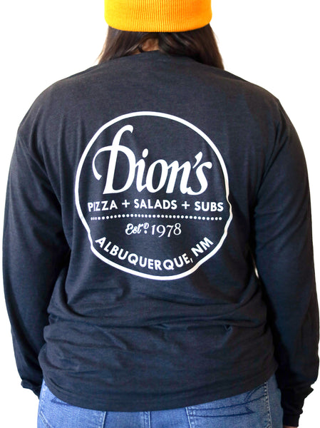 A woman wearing a black Est. 1978 - Long Sleeve Tee that says Dion's, pizza, salads, & subs, Albuquerque, NM. 