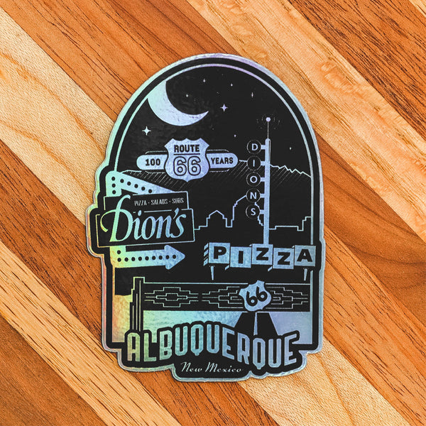 The Route 66 Centennial Sticker from Dion's Fan Shop showcases retro signage for Dion's Pizza, Route 66, and Albuquerque, New Mexico against a cityscape and wood background—a must-have for classic Americana fans.