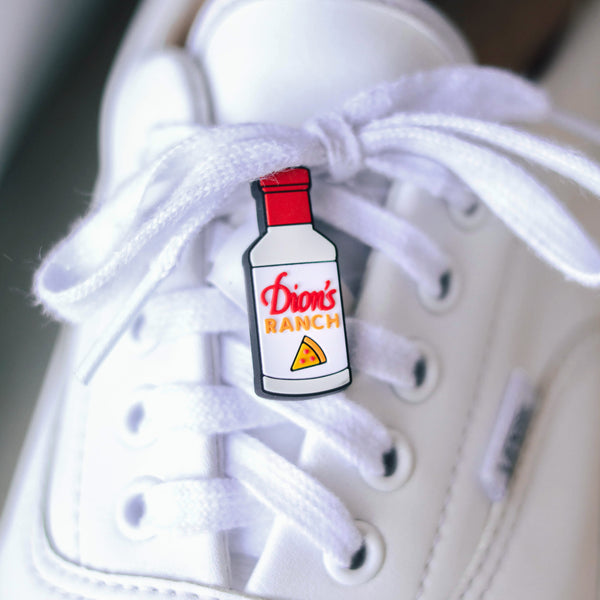 A white Dion's Fan Shop Ranch Bottle Shoe Charm shoe with a bottle of ranch dressing on it.